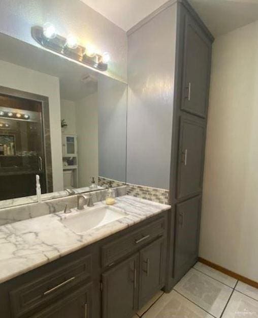 bathroom featuring tile patterned flooring, decorative backsplash, and vanity