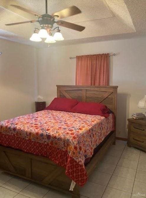 bedroom featuring ceiling fan, light tile patterned flooring, and a textured ceiling