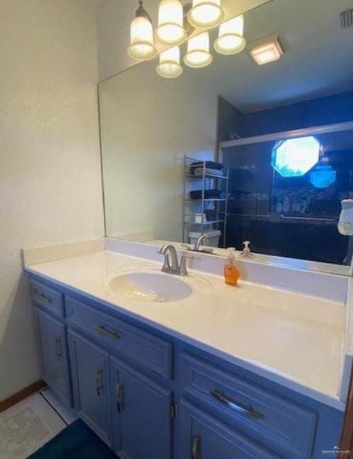 bathroom featuring tile patterned flooring, vanity, and walk in shower