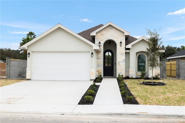 view of front facade featuring an attached garage, concrete driveway, stone siding, stucco siding, and a front yard