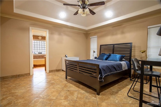 tiled bedroom with ceiling fan, a raised ceiling, ensuite bathroom, and crown molding