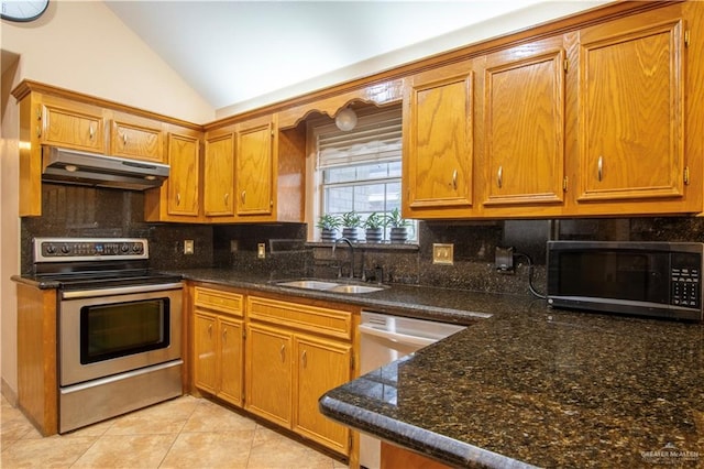 kitchen with lofted ceiling, exhaust hood, sink, dark stone countertops, and appliances with stainless steel finishes