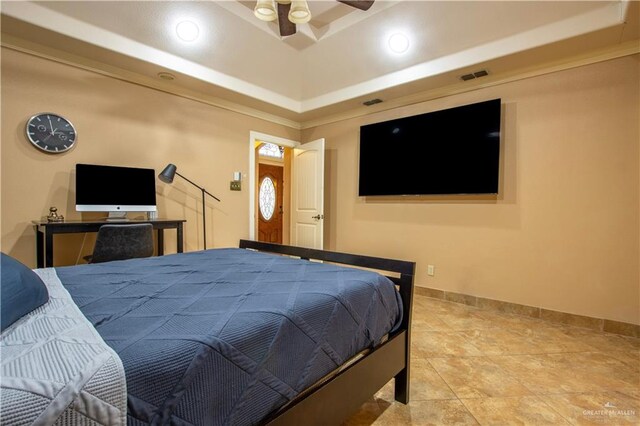 tiled bedroom with a raised ceiling and ceiling fan