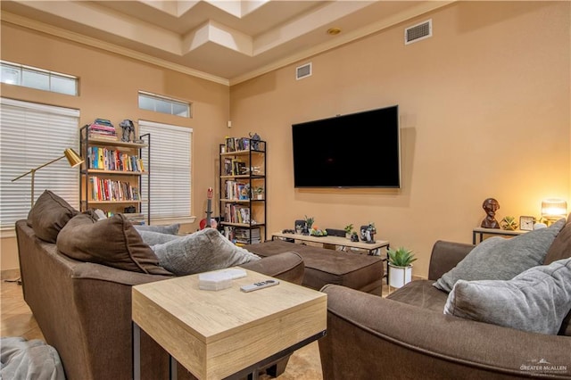 living room featuring a towering ceiling, a raised ceiling, and crown molding