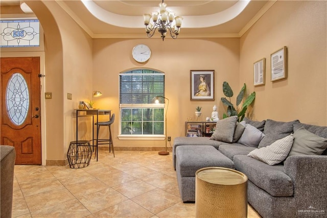 living room featuring a high ceiling, tile patterned floors, crown molding, a chandelier, and a tray ceiling