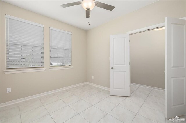 unfurnished bedroom with light tile patterned floors and ceiling fan