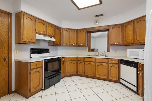 kitchen with under cabinet range hood, visible vents, white appliances, and brown cabinets