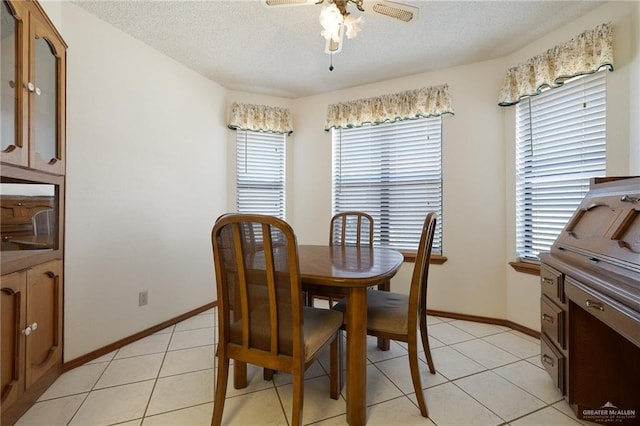 dining area featuring a textured ceiling, plenty of natural light, light tile patterned flooring, and ceiling fan