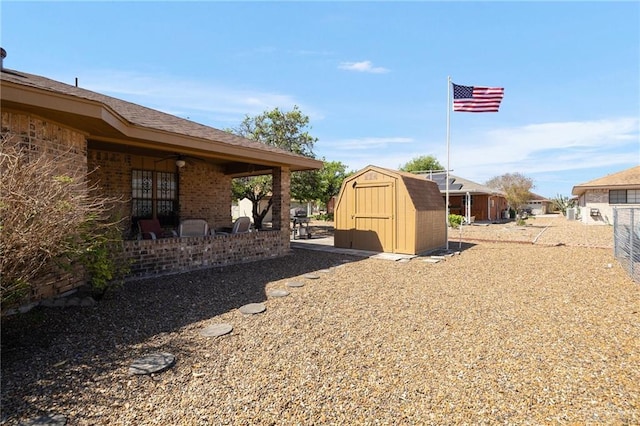 view of yard featuring an outdoor structure, a storage unit, a ceiling fan, and a patio area