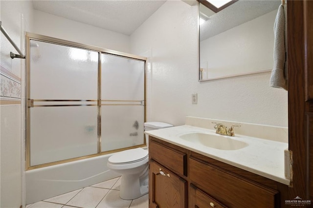 full bath with toilet, a textured ceiling, tile patterned flooring, enclosed tub / shower combo, and vanity