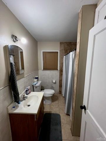 910 Bryce Dr, Mission, TX 78572 - full bathroom featuring tile walls, vanity, tile patterned flooring, and a shower with shower curtain