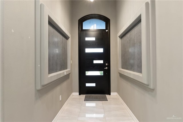 tiled foyer entrance with baseboards