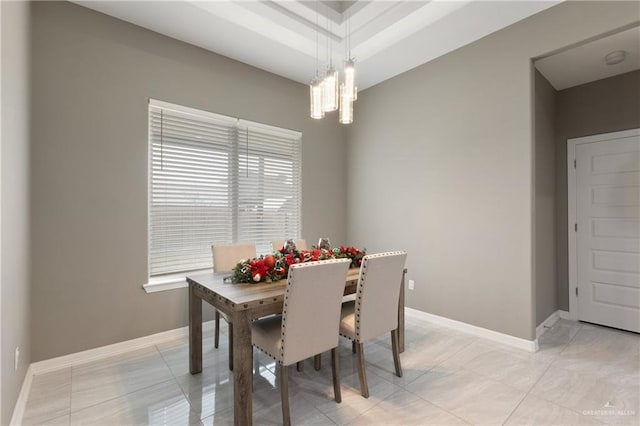 dining space with light tile patterned flooring, baseboards, and a chandelier