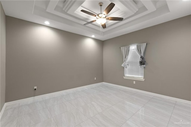 empty room with a tray ceiling, baseboards, and ceiling fan