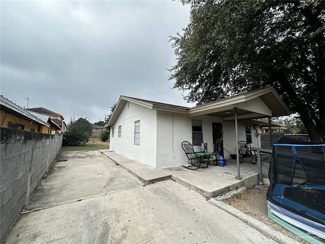 rear view of house with a patio and a trampoline