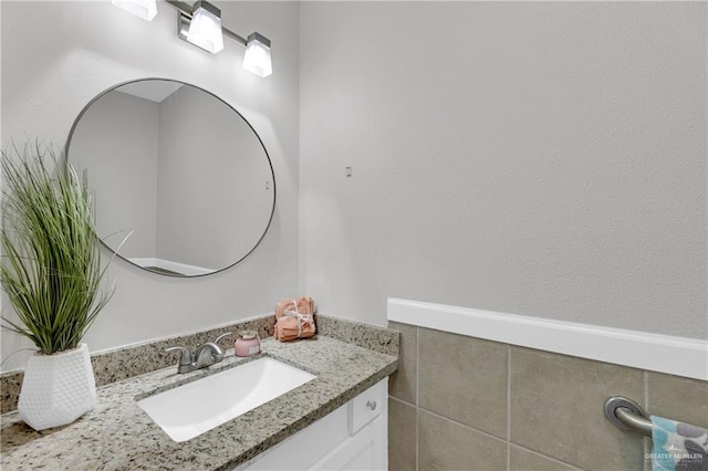 bathroom with vanity and tile walls