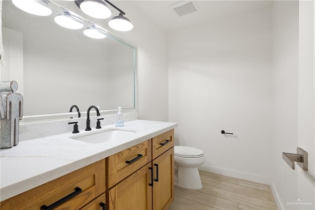 11115 N La Homa Rd, Mission, TX 78574 - bathroom featuring vanity, toilet, wood finished floors, and baseboards