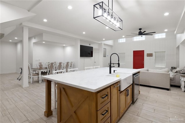 11115 N La Homa Rd, Mission, TX 78574 - kitchen featuring a sink, open floor plan, brown cabinets, a ceiling fan, and light wood-style flooring