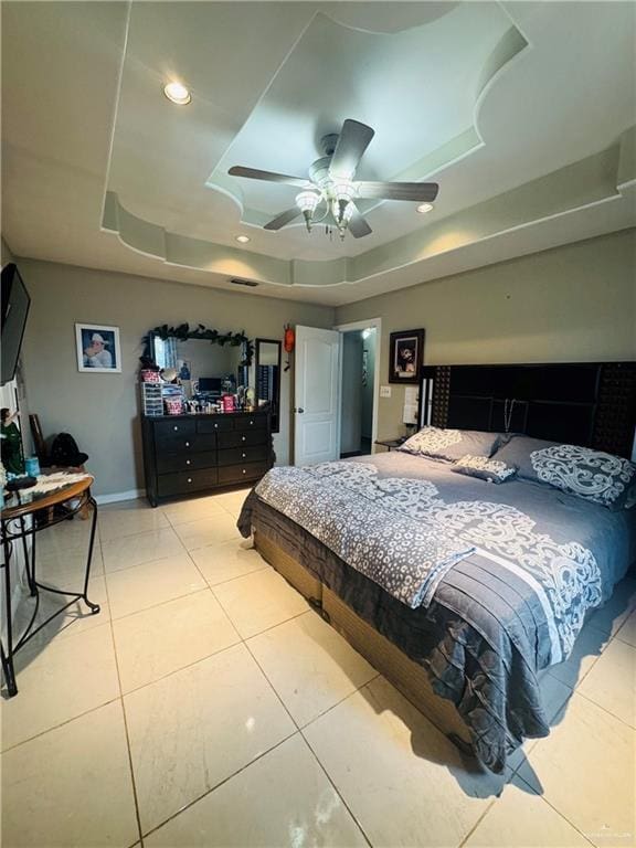 bedroom with light tile patterned floors, baseboards, ceiling fan, a tray ceiling, and recessed lighting