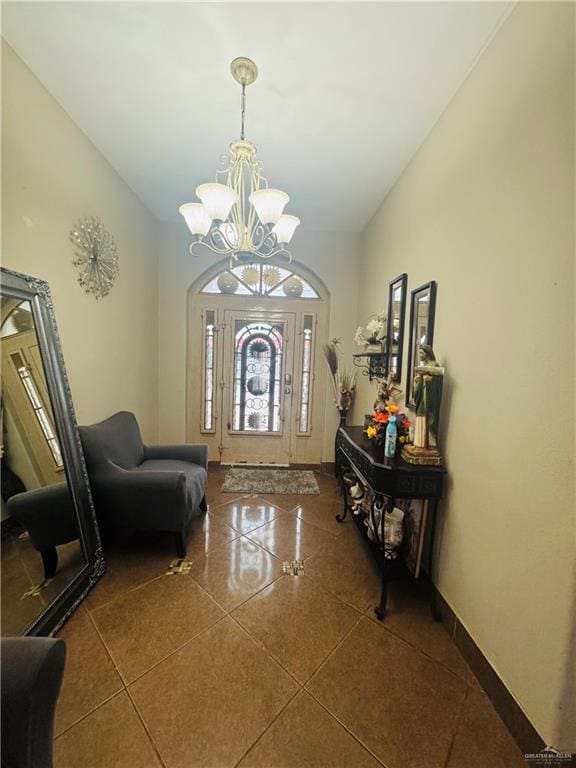 tiled foyer featuring lofted ceiling, a notable chandelier, and baseboards