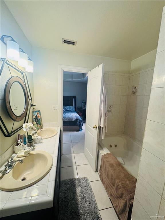 ensuite bathroom featuring double vanity, tile patterned flooring, visible vents, and a sink