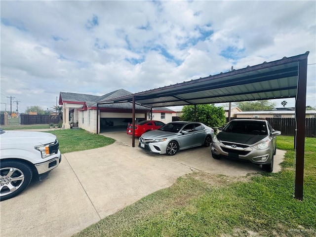 view of parking with driveway and fence