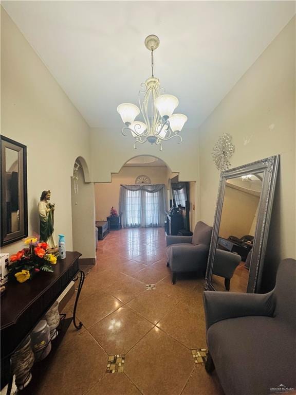 hall featuring arched walkways, high vaulted ceiling, tile patterned flooring, and a notable chandelier