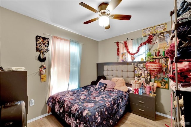 bedroom with light wood finished floors, ceiling fan, and baseboards