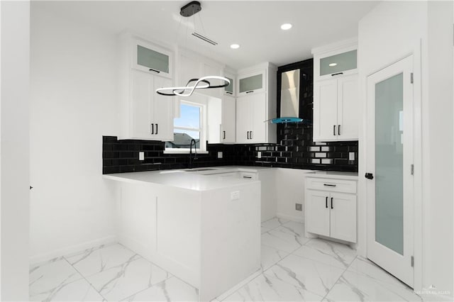 1922 Lime St, San Juan, TX 78589 - kitchen with light marble finish floors, a sink, a peninsula, recessed lighting, and glass insert cabinets