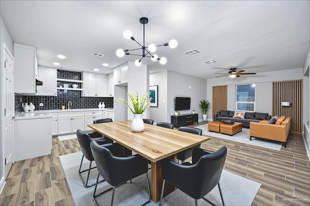 314 N Veterans Blvd, Edinburg, TX 78541 - dining area with wood tiled floors, a ceiling fan, a chandelier, and recessed lighting