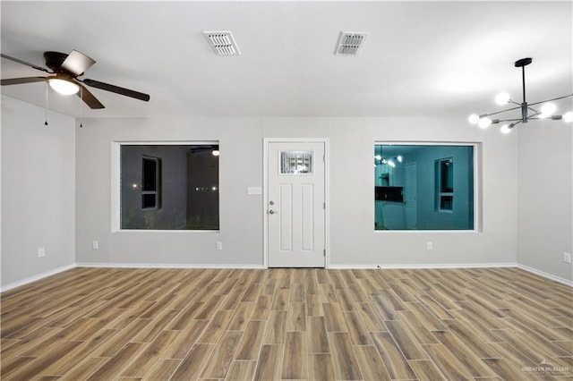 314 N Veterans Blvd, Edinburg, TX 78541 - unfurnished living room featuring wood finished floors, ceiling fan, and a chandelier