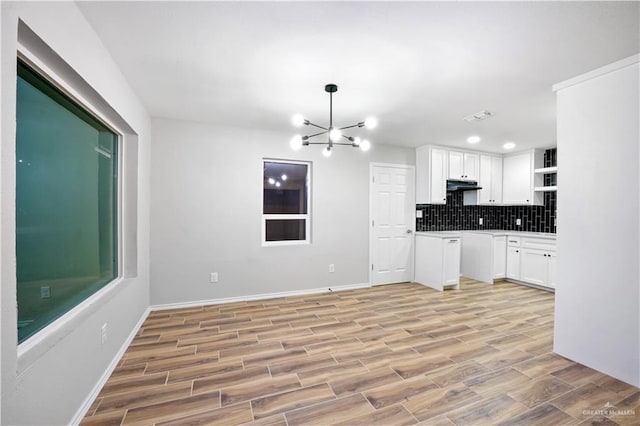 314 N Veterans Blvd, Edinburg, TX 78541 - kitchen with white cabinets, under cabinet range hood, open shelves, backsplash, and light wood-type flooring