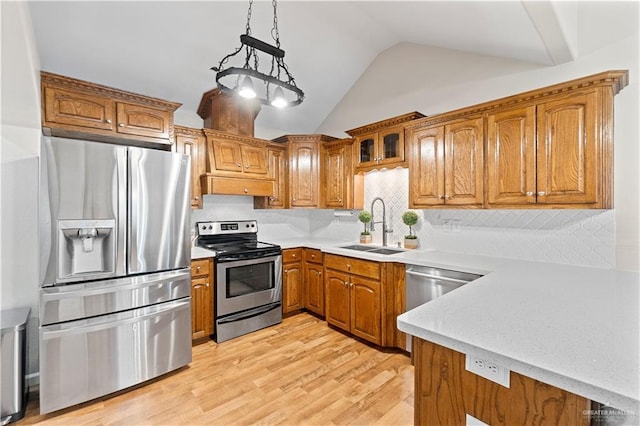 kitchen featuring pendant lighting, appliances with stainless steel finishes, light hardwood / wood-style floors, sink, and decorative backsplash