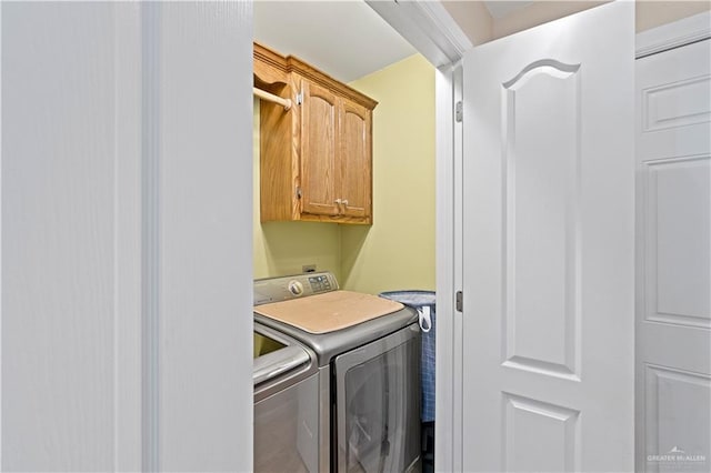 washroom featuring cabinets and washer and clothes dryer