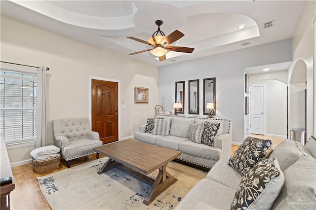 living room featuring coffered ceiling, light wood-type flooring, and ceiling fan