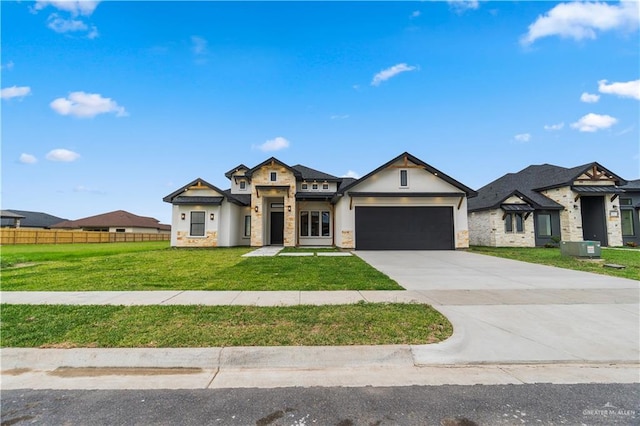 136 Finch Ln, Los Fresnos, TX 78566 - view of front of house with stone siding, a garage, driveway, and stucco siding