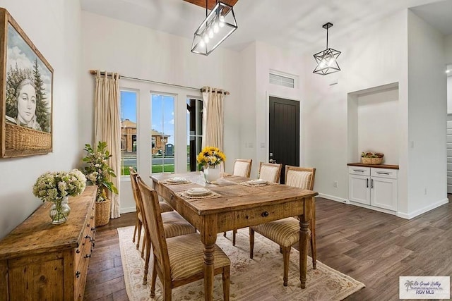 136 Finch Ln, Los Fresnos, TX 78566 - dining area with a towering ceiling, dark wood-style floors, and baseboards