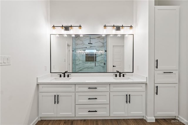136 Finch Ln, Los Fresnos, TX 78566 - full bath featuring a marble finish shower, wood finished floors, double vanity, and baseboards