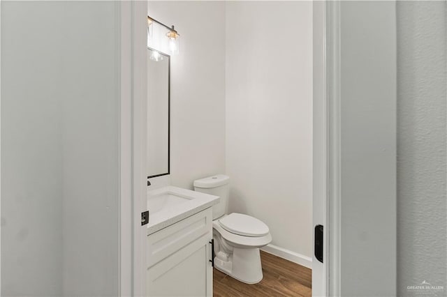 136 Finch Ln, Los Fresnos, TX 78566 - half bathroom featuring vanity, wood finished floors, and toilet