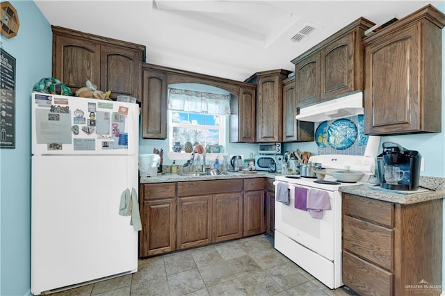 722 E Fay St, Edinburg, TX 78539 - kitchen with white appliances, under cabinet range hood, a sink, light countertops, and a raised ceiling