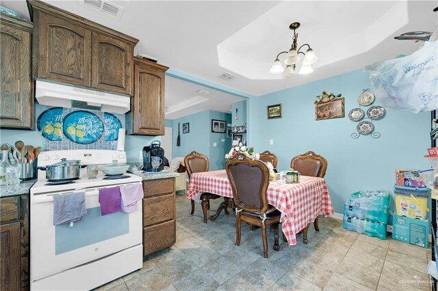 722 E Fay St, Edinburg, TX 78539 - kitchen with white electric stove, under cabinet range hood, a chandelier, light countertops, and a raised ceiling