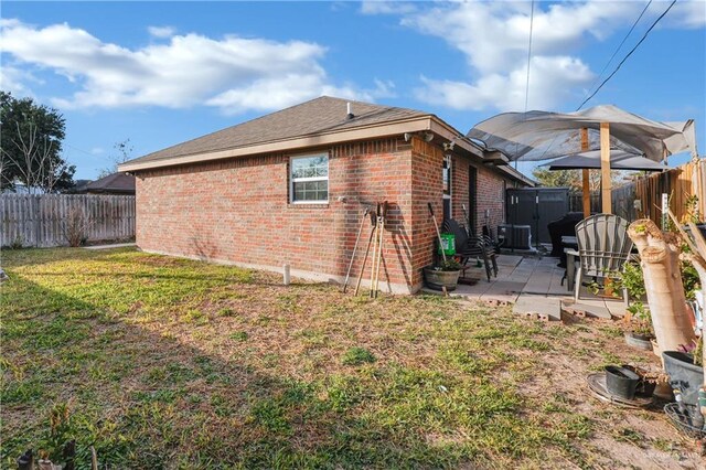 722 E Fay St, Edinburg, TX 78539 - rear view of house with brick siding, a patio area, a storage unit, an outbuilding, and cooling unit