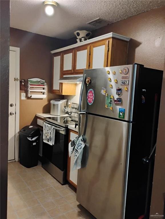 kitchen with stainless steel appliances and a textured ceiling