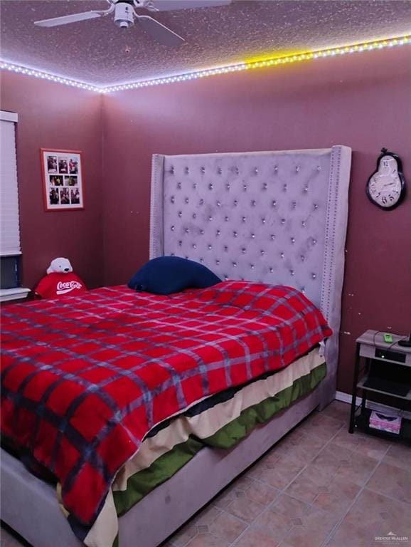 tiled bedroom with ceiling fan and a textured ceiling