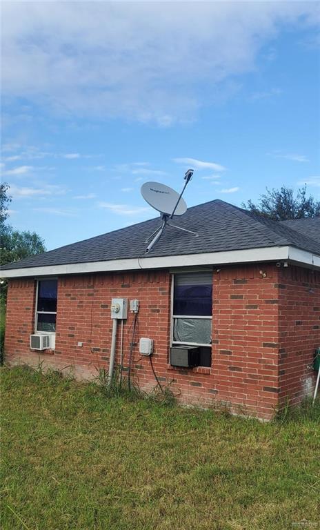 view of property exterior with cooling unit and a lawn