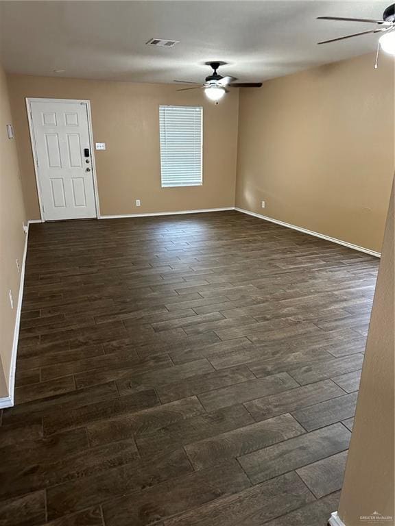 empty room with ceiling fan and dark wood-type flooring