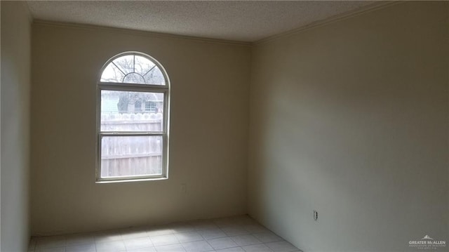 empty room featuring a textured ceiling and ornamental molding