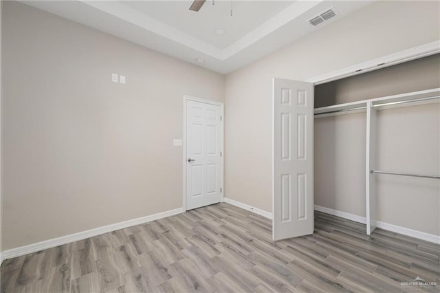 unfurnished bedroom featuring light wood-style floors, a closet, visible vents, and baseboards