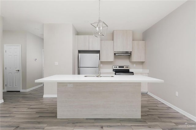 kitchen featuring a kitchen island with sink, under cabinet range hood, light countertops, freestanding refrigerator, and stainless steel electric stove