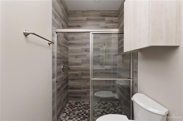 bathroom featuring a stall shower and toilet